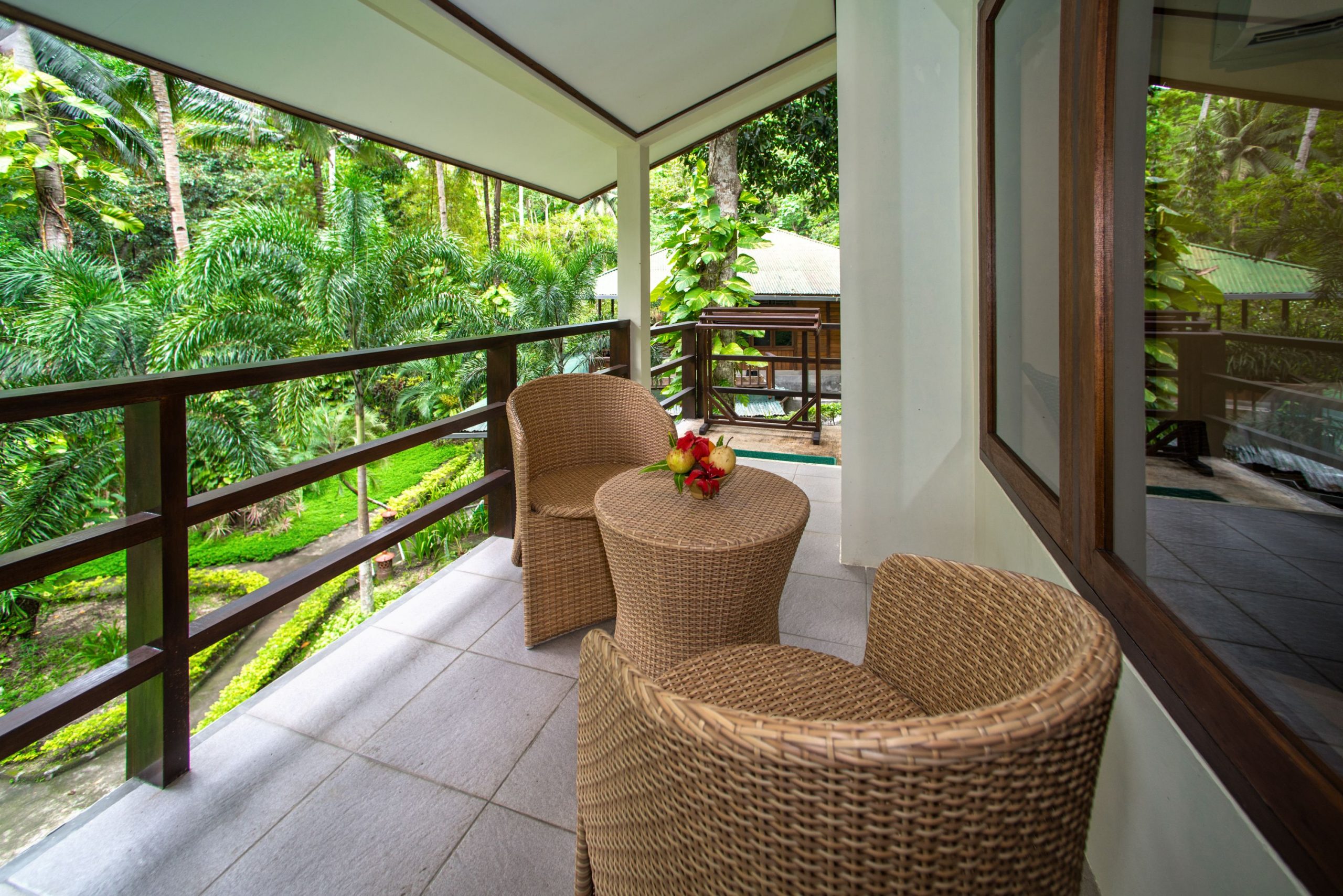 Lembeh Resort POV from Balcony View with two whicker chairs and side table